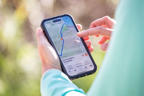 Hiker checking the route on the Macs Adventure app